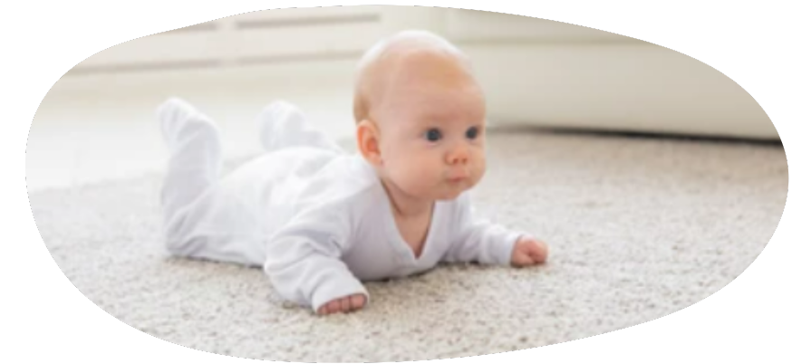 bébé sur le ventre disposé au jeu d'éveil sur tapis